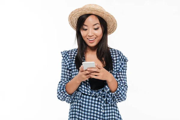 Portrait of a joyful young asian woman in dress and hat — Stock Photo, Image