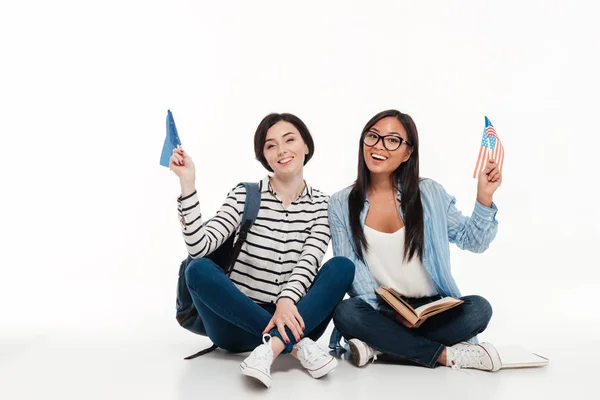 Dos jóvenes estudiantes sonrientes sosteniendo banderas — Foto de Stock