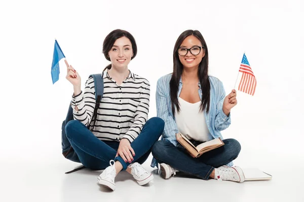 Twee gelukkig vrolijke vrouwelijke studenten houdt ons vlaggen — Stockfoto