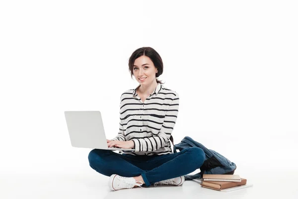 Retrato de uma adolescente sorridente com mochila usando laptop — Fotografia de Stock