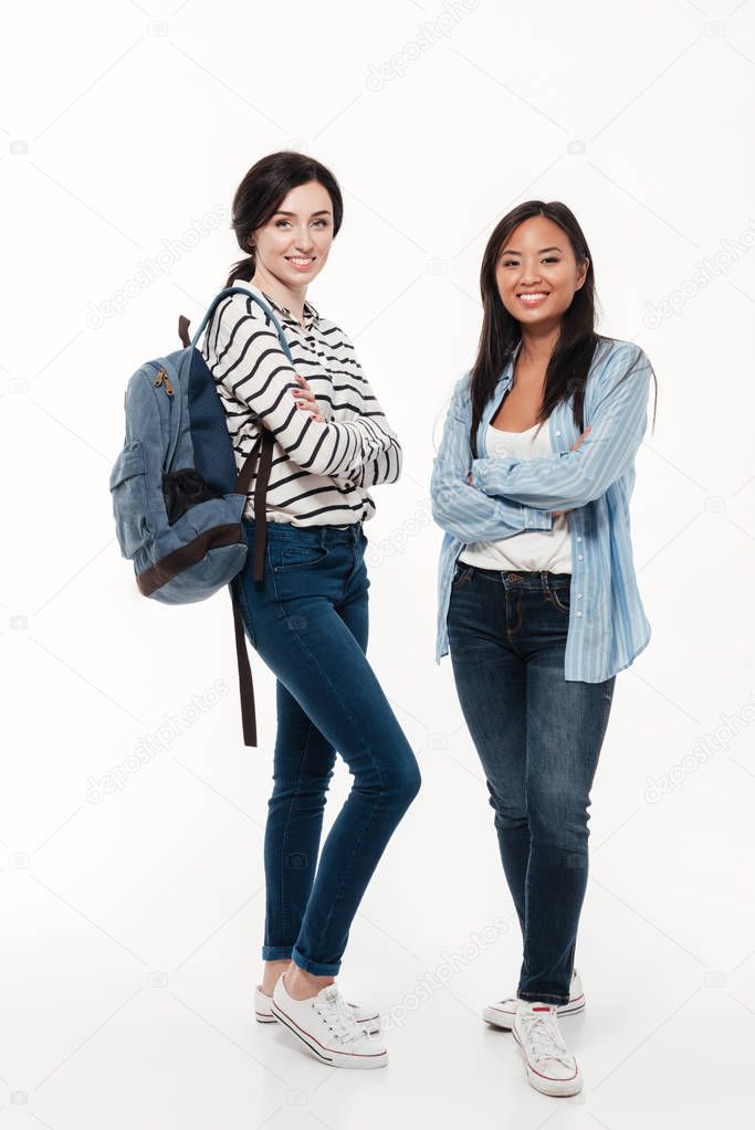 Couple of two multiethnic female students with backpack