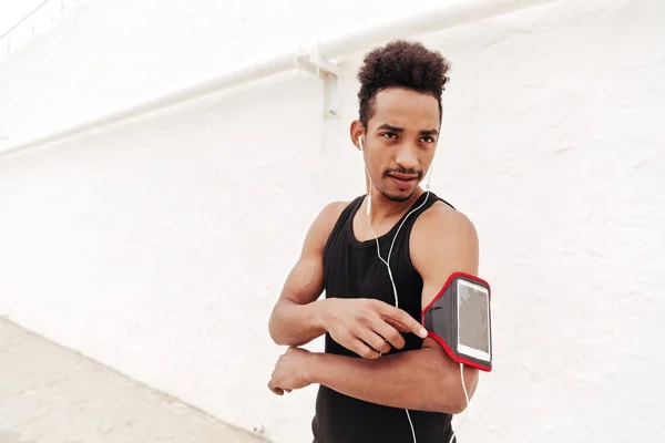 Jovem desportista africano concentrado ouvindo música . — Fotografia de Stock