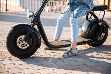 Bir motor bisiklet üzerinde oturan bir kadın Resim kırpılmış