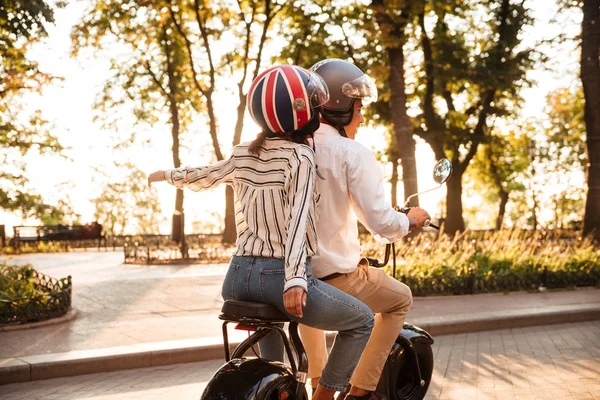 Back view of young african couple rides on modern motorbike — Stock Photo, Image