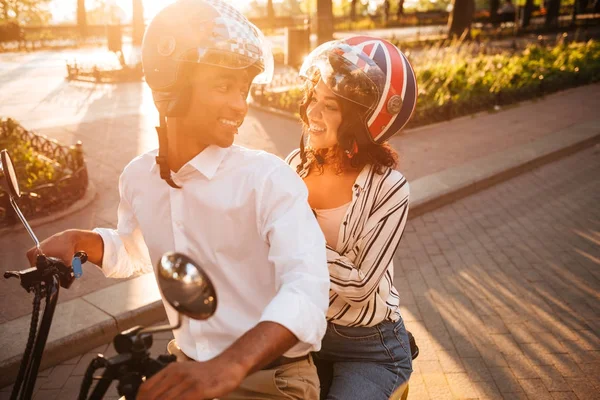 Glückliches afrikanisches Paar fährt auf modernem Motorrad im Park — Stockfoto