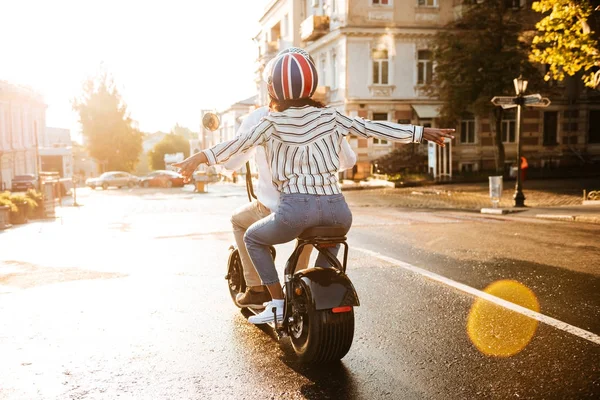 現代のバイクに乗ってアフリカの幸せなカップルの背面図 — ストック写真