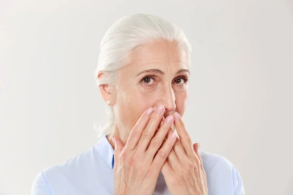 Close-up portrait of charming old lady, covering her mouth with — Stock Photo, Image