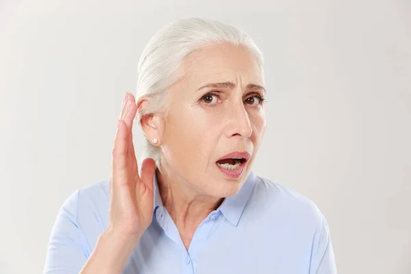 Close-up de encantadora mulher idosa, de mão dada por sua orelha e — Fotografia de Stock