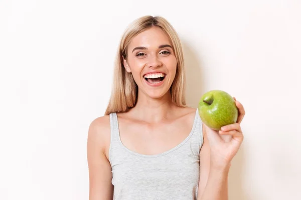Portré egy vidám lány fehérnemű mutató zöld alma — Stock Fotó