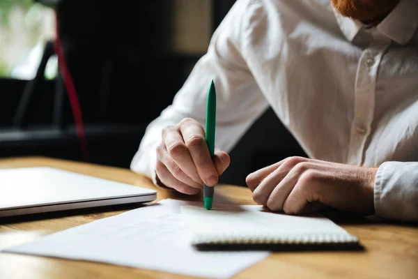 Photo recadrée de l'homme en chemise blanche tenant un stylo vert — Photo