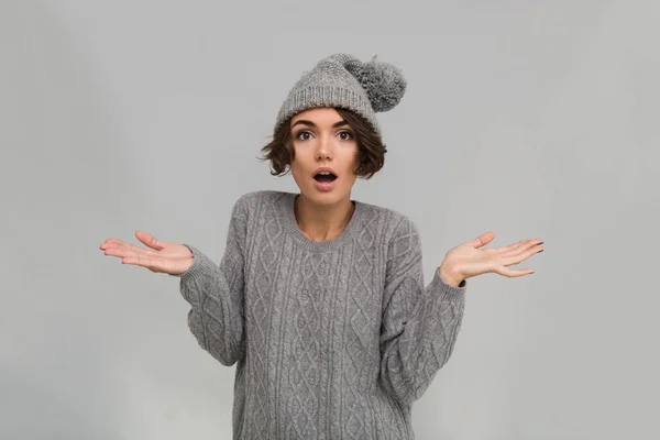 Schockierte junge Frau in Pullover und warmem Hut — Stockfoto