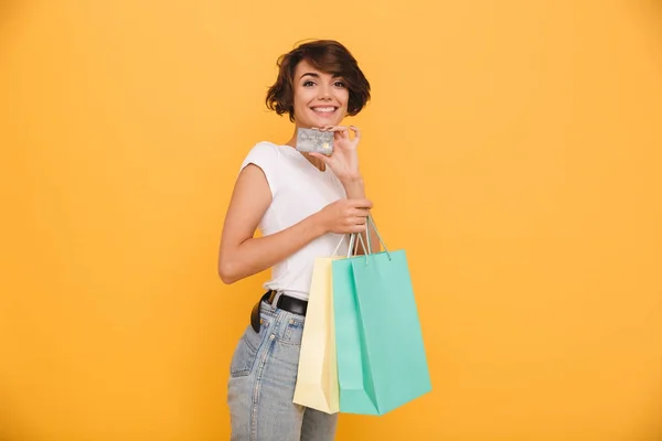 Retrato de una chica alegre sonriente sosteniendo bolsas de compras —  Fotos de Stock