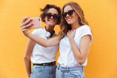 İki neşeli genç genç kız bir selfie alarak güneş gözlüğü