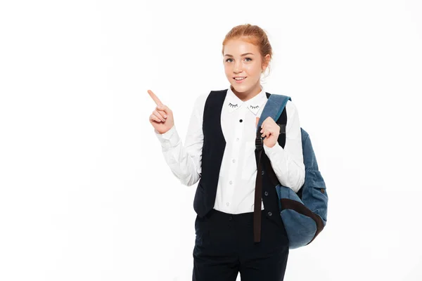 Улыбающаяся студентка-гигнер с рюкзаком, указывающим вверх — стоковое фото