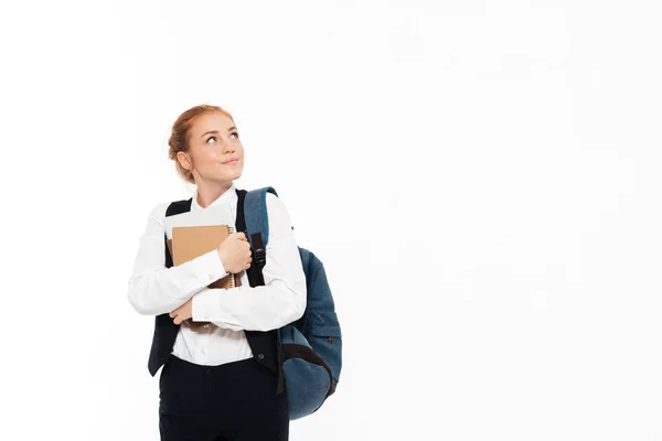 Pensive gigner student woman with backpack hugging notebooks — Stock Photo, Image