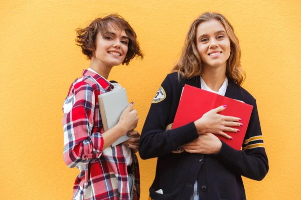 Portret van twee jonge tienermeisjes met boeken permanent — Stockfoto