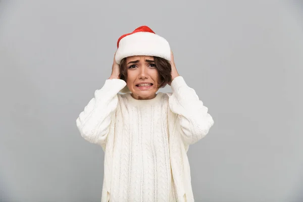 Portrait of a confused puzzled girl in christmas hat — Stock Photo, Image