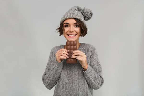 Fröhliche Frau in Pullover und warmem Hut mit Schokolade. — Stockfoto