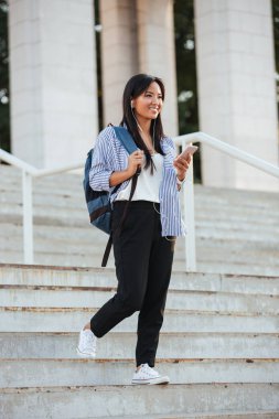 Pretty Asya öğrenci musi için dinlerken merdivenlerden aşağı yürüyüş