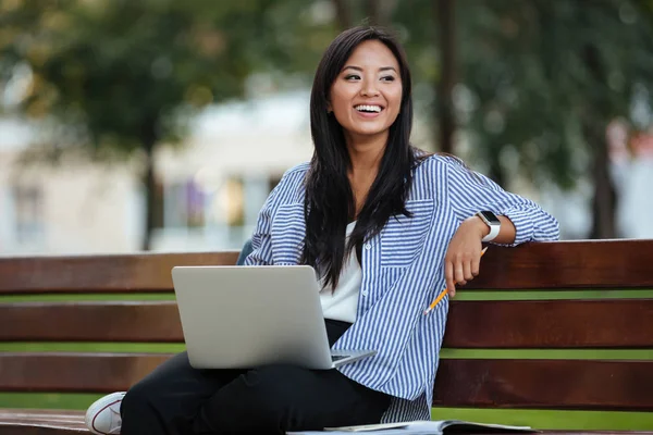 Porträtt av en ganska skrattande asiatiska kvinnlig student sitter — Stockfoto