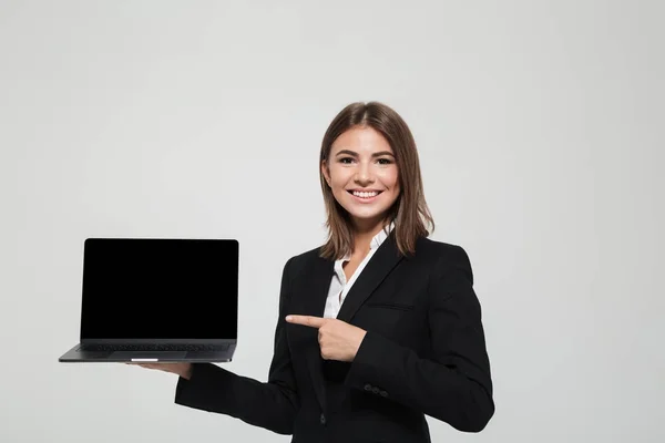 Porträt einer lächelnden Geschäftsfrau im Anzug, die mit dem Finger zeigt — Stockfoto