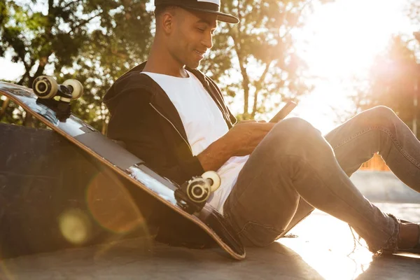 Afrikaanse jongeman, surfen op het web met behulp van de smartphone — Stockfoto