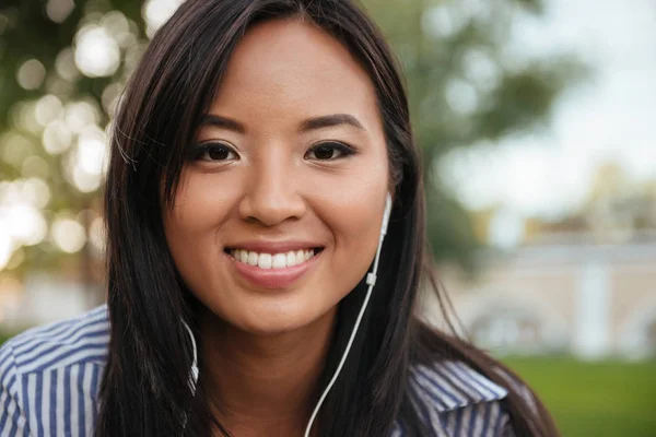 Close-up foto van jonge vrolijke Aziatische vrouw muziek beluisteren, — Stockfoto