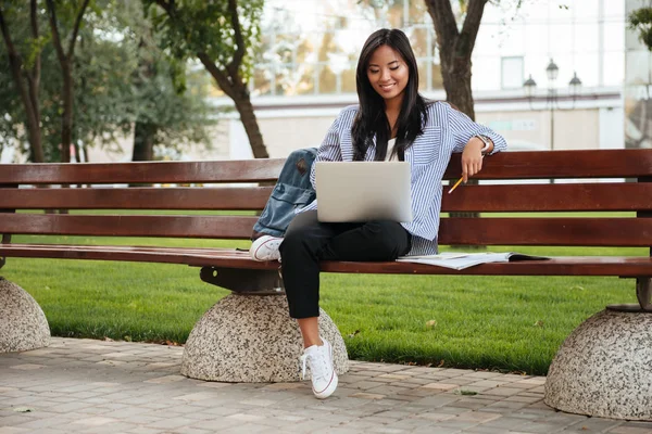 Foto de joven feliz asiática estudiante relajante con ordenador portátil , —  Fotos de Stock