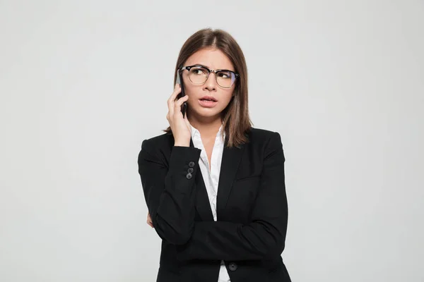 Portrait of a confused young businesswoman in eyeglasses — Stock Photo, Image