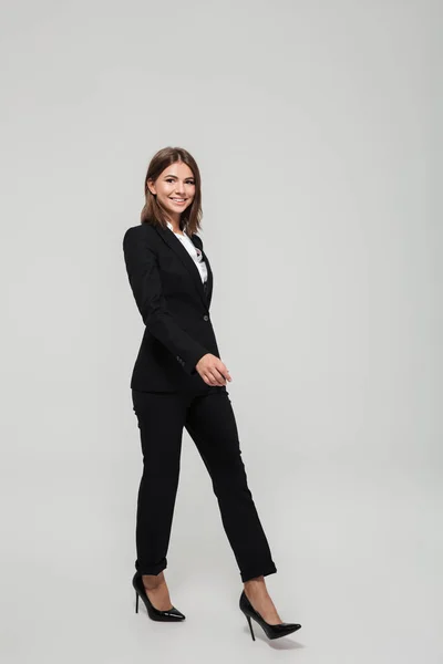 Full length portrait of a smiling beautiful woman in suit — Stock Photo, Image