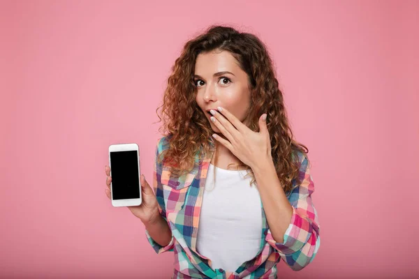 Senhora surpreso mostrando smartphone com tela em branco isolado — Fotografia de Stock