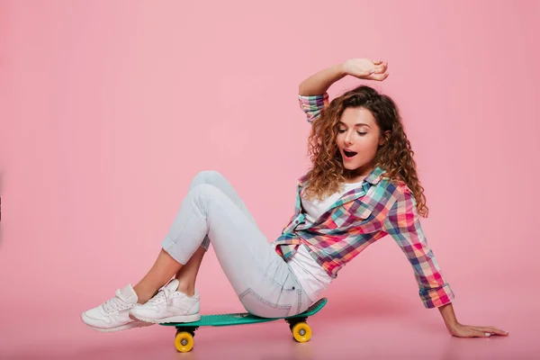 Ung dam poserar på skateboard idolated över rosa — Stockfoto