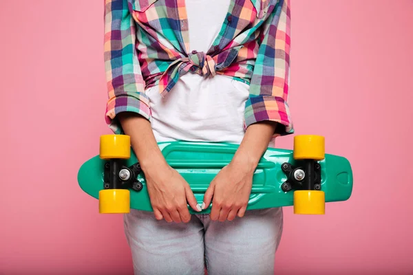 Bella signora abbracciando il suo skateboard e posa isolata — Foto Stock
