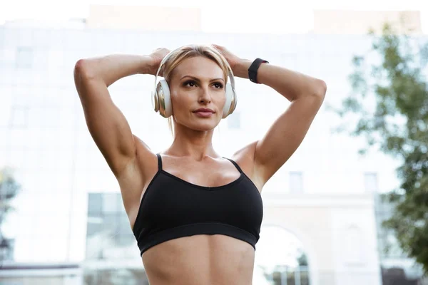 Mujer deportiva fuerte concentrada escuchando música — Foto de Stock