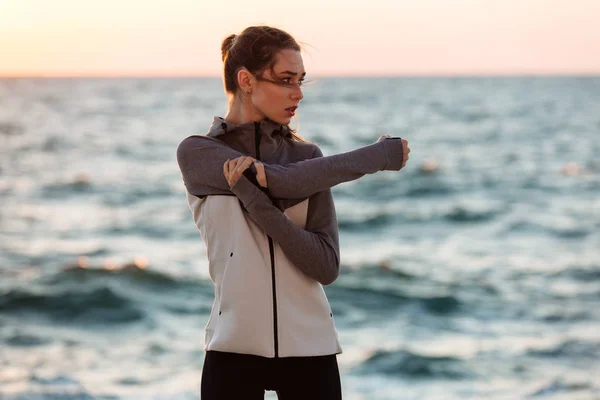 Retrato de mujer hermosa deporte estirando su músculo del brazo en t — Foto de Stock