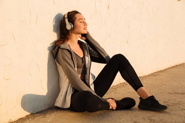 Foto di una giovane donna sorridente che ascolta musica da vicino — Foto Stock