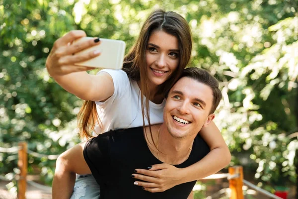 Porträt eines lächelnden attraktiven Paares, das verliebt Selfie macht — Stockfoto