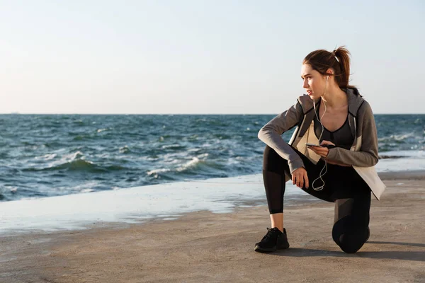 Foto av unga friska sport kvinna sitter på knä, hålla smar — Stockfoto
