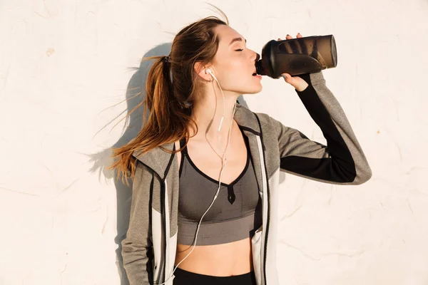 Close-up portrait of charming brunette sport woman drinking wate — Stock Photo, Image