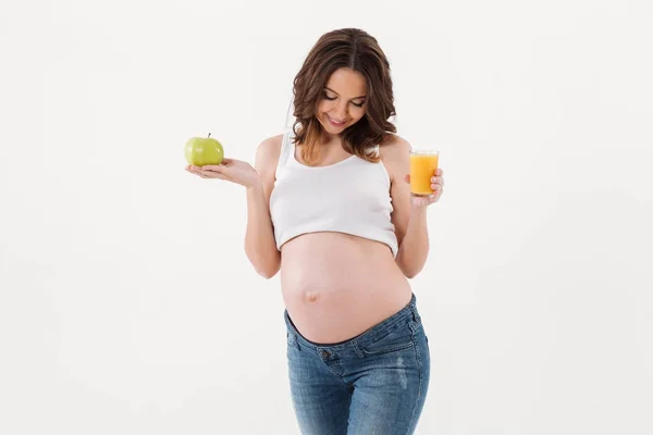 Glad gravid kvinna dricka saft. Tittar åt sidan. — Stockfoto