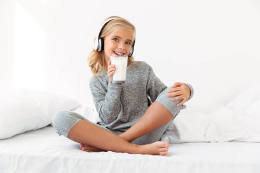 Gri pijama MIL bardak holding neşeli küçük sarışın kız