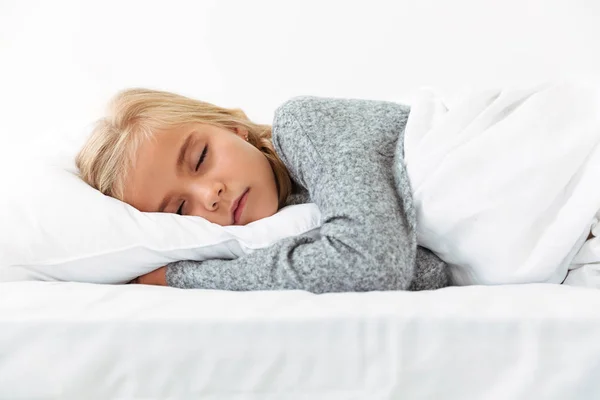 Närbild av leende liten flicka med gåva i sängen — Stockfoto