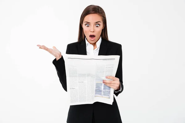 Chockad affärskvinna hålla tidningen. — Stockfoto