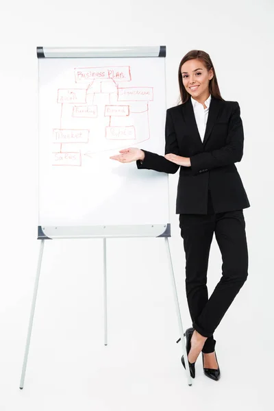 Alegre bonita mujer de negocios cerca del plan de negocios que lo muestra . — Foto de Stock