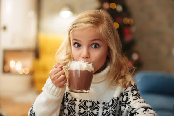 Beautiful little blonde girl drinking cacao with marshmallow on — Stock Photo, Image