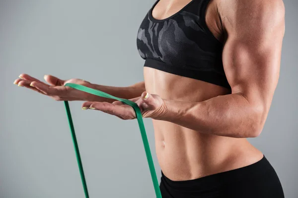 Beskuren bild av musculary kvinna träning med motstånd band — Stockfoto