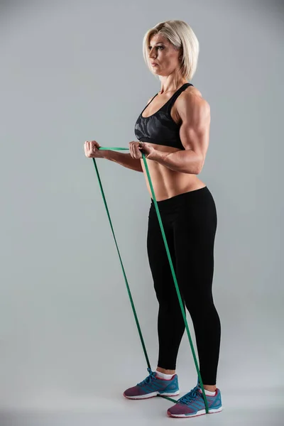 Φωτογραφία πλήρους μήκους ισχυρή σπορ γυναίκας άσκηση με resista — Φωτογραφία Αρχείου