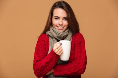 Mutlu beyaz kadın sıcak çay içme Kazak giymiş.