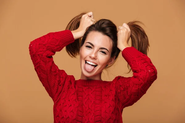 Primer plano de la joven divertida mostrando su lengua, sosteniendo h —  Fotos de Stock