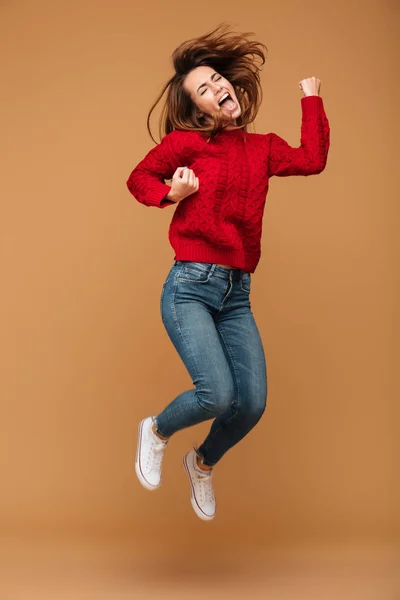 Кричуща біла жінка, одягнена в светр стрибає — стокове фото